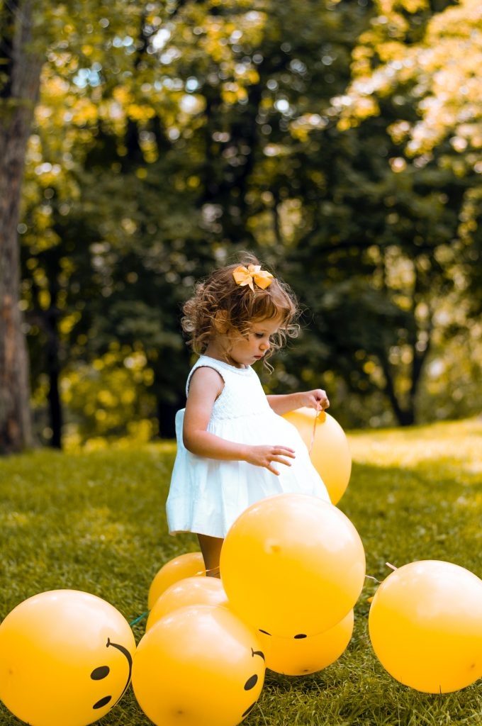 Meisje speelt met een bal in het gras